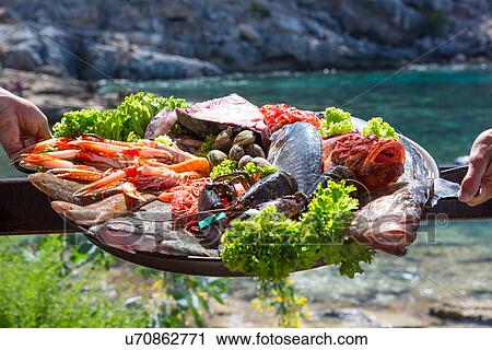 Hand of waitress and waiter with fresh seafood platter, Mallorca, Spain View Large Photo Image Stock Image - Hand of waitress and waiter with fresh seafood platter, Mallorca, Spain. Fotosearch