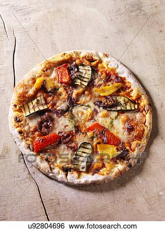 Stock Photograph - Italian chargrilled pizza with courgettes, peppers, onions, tomatoes and cheese. Fotosearch