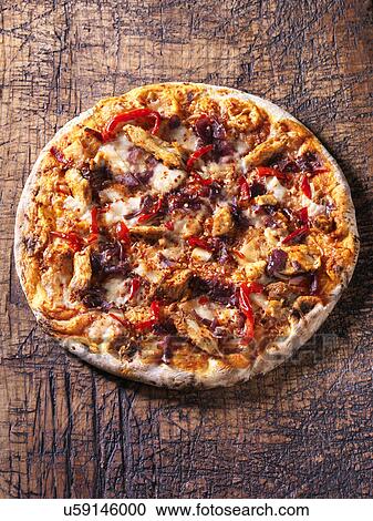 Stock Image - Italian spicy chicken pizza with red chillies, red onion and mozzarella. Fotosearch