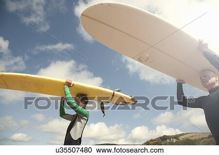 Man and teenage boy carrying surfboards View Large Photo Image Stock Image - Man and teenage boy carrying surfboards. Fotosearch