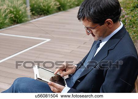 Man using digital tablet View Large Photo Image Picture - Man using digital tablet. Fotosearch