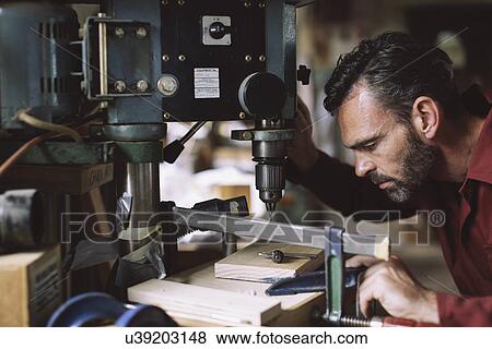 Mature craftsman drilling component in pipe organ workshop View Large Photo Image Stock Photo - Mature craftsman drilling component in pipe organ workshop. Fotosearch