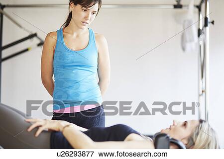 Mature female student lying on trapeze table in pilates gym View Large Photo Image Stock Photo - Mature female student lying on trapeze table in pilates gym. Fotosearch