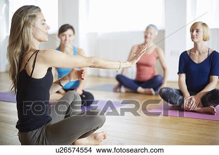 Mature female tutor with arms outstretched in pilates class View Large Photo Image Picture - Mature female tutor with arms outstretched in pilates class. Fotosearch