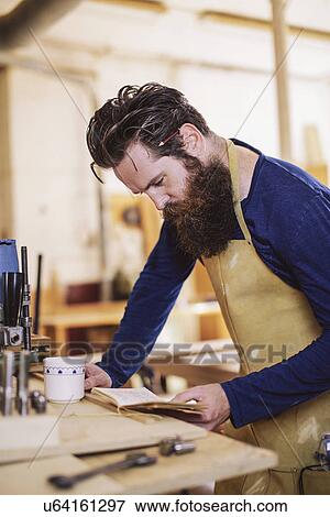 Mid adult craftsman checking notebook in organ workshop View Large Photo Image Stock Photo - Mid adult craftsman checking notebook in organ workshop. Fotosearch