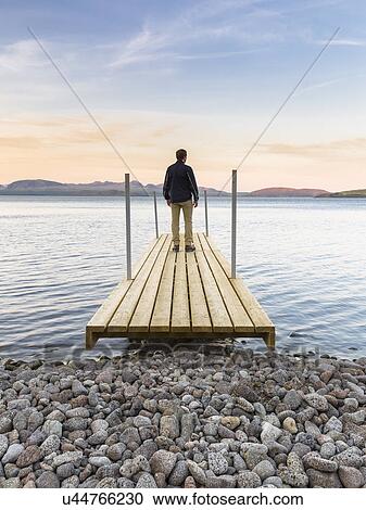 Mid adult man standing on jetty, looking out across water, Thingvellir, Iceland View Large Photo Image Stock Image - Mid adult man standing on jetty, looking out across water, Thingvellir, Iceland. Fotosearch