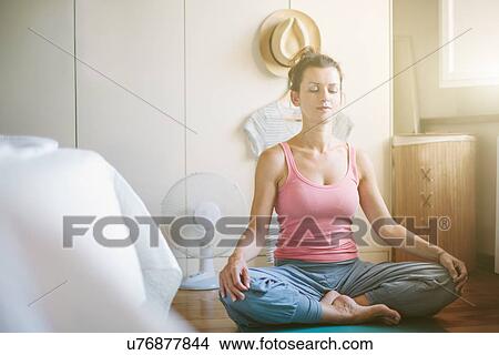 Mid adult woman in yoga lotus position in bedroom View Large Photo Image Picture - Mid adult woman in yoga lotus position in bedroom. Fotosearch