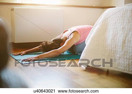 Mid adult woman in yoga position on bedroom floor View Large Photo Image Stock Image - Mid adult woman in yoga position on bedroom floor. Fotosearch