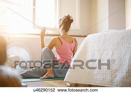 Mid adult woman practicing yoga on bedroom floor View Large Photo Image Stock Image - Mid adult woman practicing yoga on bedroom floor. Fotosearch