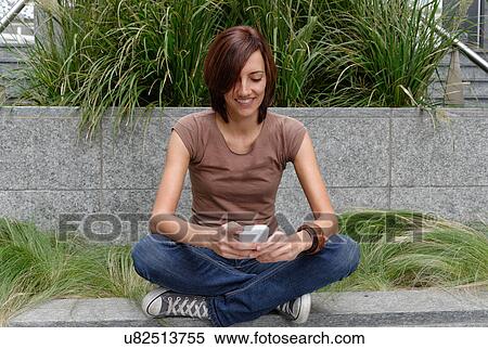 Stock Photography - Mid adult woman using mobile phone. Fotosearch
