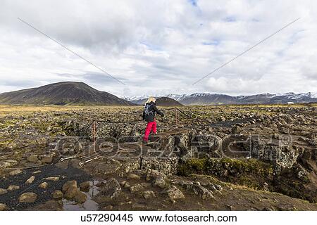 Mid adult woman walking across footbridge, Blafjoll, Iceland View Large Photo Image Stock Photography - Mid adult woman walking across footbridge, Blafjoll, Iceland. Fotosearch