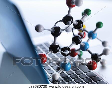 Stock Image - Molecular model sitting on top of lap top computer keyboard to illustrate science education and computer aided research. Fotosearch