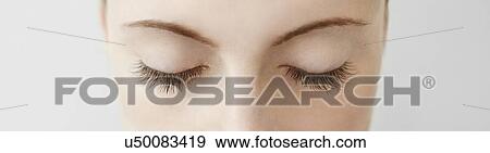 Stock Photo - Panoramic close up of mid adult womans closed eyes. Fotosearch