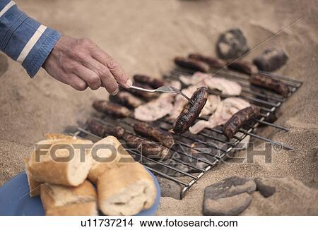 Picture - Person barbecuing sausages. Fotosearch