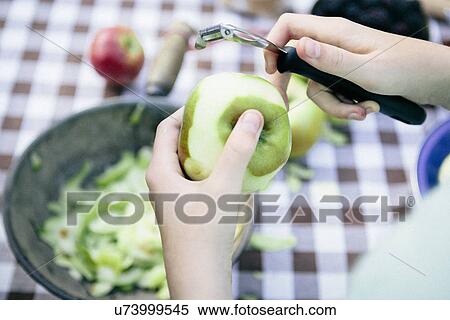 Stock Photography - Person peeling apple. Fotosearch