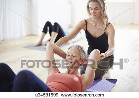 Pilates teacher holding student arms in class View Large Photo Image Stock Photo - Pilates teacher holding student arms in class. Fotosearch