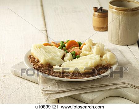 Stock Image - Plate of cottage pie with cauliflower cheese, peas and carrots. Fotosearch