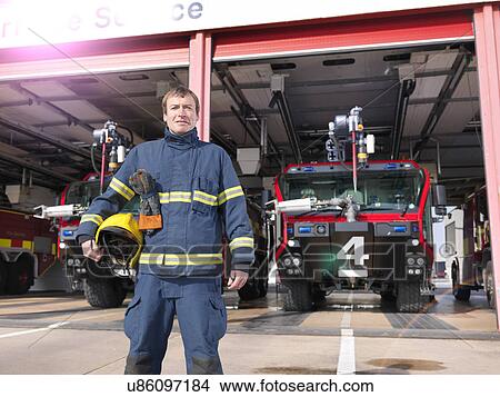 Portrait of fireman in front of fire engines in airport fire station View Large Photo Image Picture - Portrait of fireman in front of fire engines in airport fire station. Fotosearch