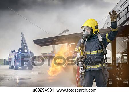 Portrait of fireman in front of simulated fire at airport training facility View Large Photo Image Stock Image - Portrait of fireman in front of simulated fire at airport training facility. Fotosearch