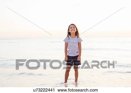 Stock Image - Portrait of girl in sea, Tuscany, Italy. Fotosearch