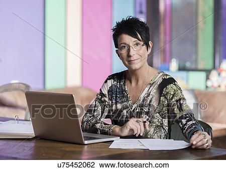 Portrait of mature seamstress using laptop in workshop office View Large Photo Image Stock Image - Portrait of mature seamstress using laptop in workshop office. Fotosearch