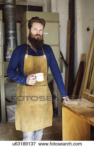 Portrait of mid adult craftsman drinking coffee in organ workshop View Large Photo Image Stock Photo - Portrait of mid adult craftsman drinking coffee in organ workshop. Fotosearch