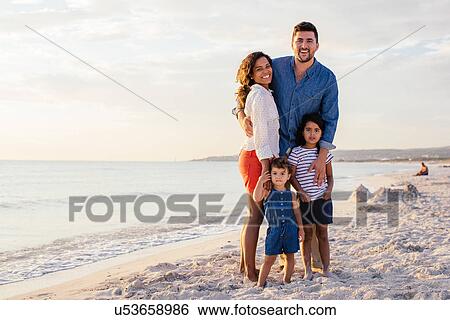 Portrait of smiling couple with two girls on beach, Tuscany, Italy View Large Photo Image Stock Photograph - Portrait of smiling couple with two girls on beach, Tuscany, Italy. Fotosearch
