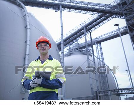Stock Photo - Portrait of worker holding digital tablet at biomass facility. Fotosearch