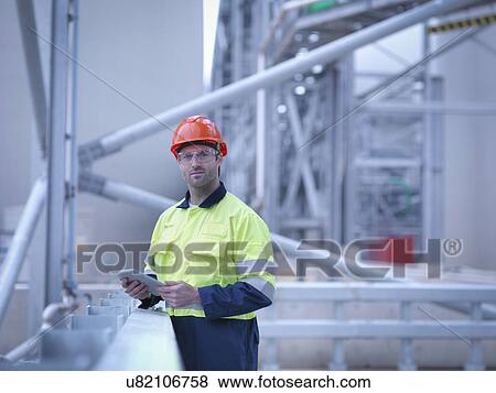 Portrait of worker holding digital tablet at biomass facility View Large Photo Image Stock Photo - Portrait of worker holding digital tablet at biomass facility. Fotosearch