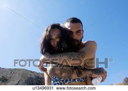 Stock Image - Portrait of young couple hugging at coast, Marseille, France. Fotosearch