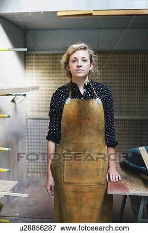 Stock Photo - Portrait of young craftswoman in organ workshop. Fotosearch