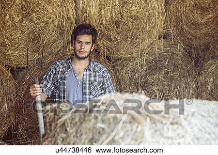 Portrait of young male farmer in straw barn with pitchfork, Premosello, Verbania, Piemonte, Italy View Large Photo Image Stock Photograph - Portrait of young male farmer in straw barn with pitchfork, Premosello, Verbania, Piemonte, Italy. Fotosearch