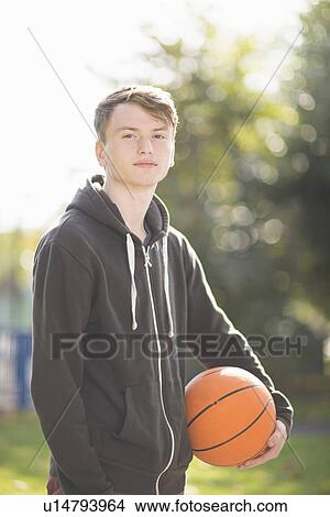 Portrait of young man holding basketball View Large Photo Image Picture - Portrait of young man holding basketball. Fotosearch