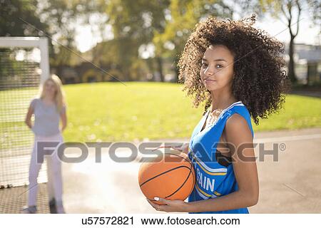 Portrait of young woman holding basketball View Large Photo Image Stock Image - Portrait of young woman holding basketball. Fotosearch