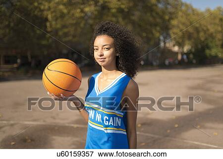 Portrait young female basketball player holding up basketball View Large Photo Image Stock Photo - Portrait young female basketball player holding up basketball. Fotosearch