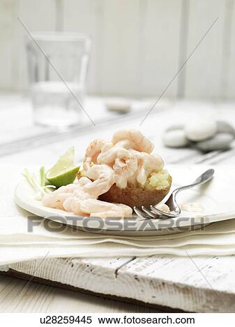 Stock Photography - Prawn cocktail jacket potato with slice of lime and spring onion garnish. Fotosearch