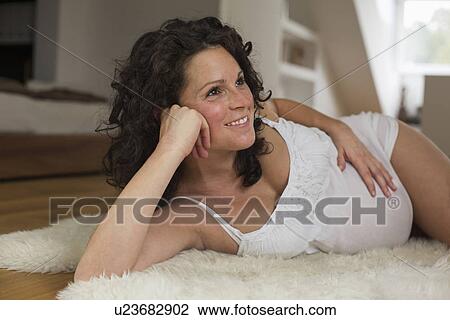Stock Image - Pregnant woman relaxing at home. Fotosearch