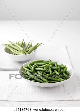 Raw green beans in bowl on cutting board and bowl of boiled green beans View Large Photo Image Stock Photo - Raw green beans in bowl on cutting board and bowl of boiled green beans. Fotosearch