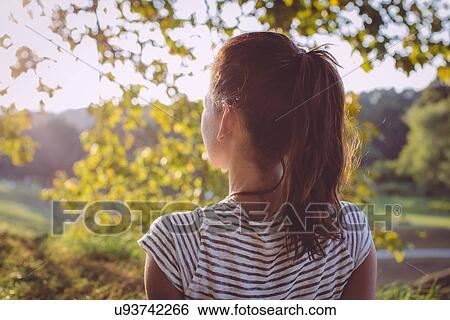 Stock Photograph - Rear view of mid adult woman looking at landscape view, Tuscany, Italy. Fotosearch