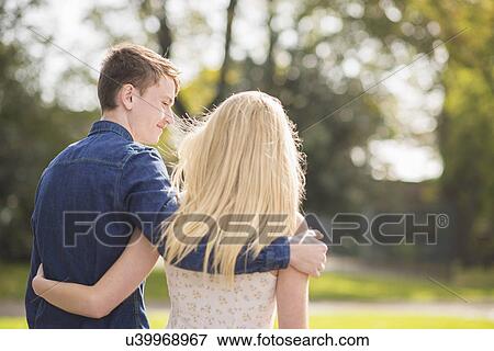Rear view of romantic young couple strolling in park View Large Photo Image Stock Photo - Rear view of romantic young couple strolling in park. Fotosearch