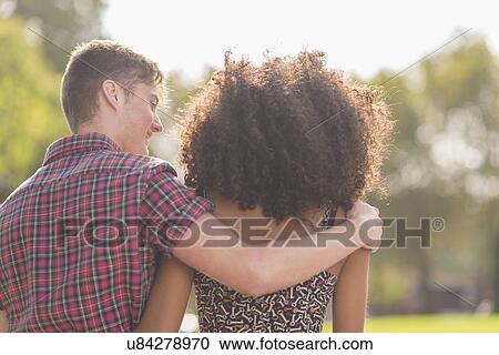 Rear view of young couple strolling in park View Large Photo Image Stock Image - Rear view of young couple strolling in park. Fotosearch