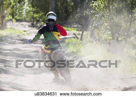 Rear view of young male motocross rider racing on forest track View Large Photo Image Stock Image - Rear view of young male motocross rider racing on forest track. Fotosearch