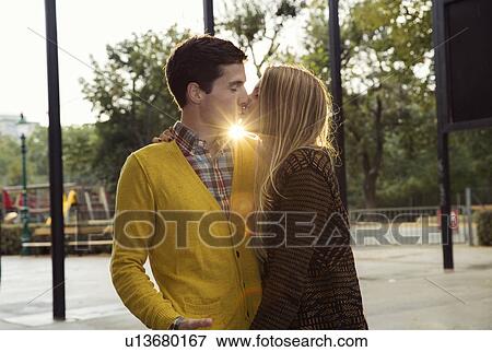 Romantic young couple kissing in park View Large Photo Image Stock Photo - Romantic young couple kissing in park. Fotosearch