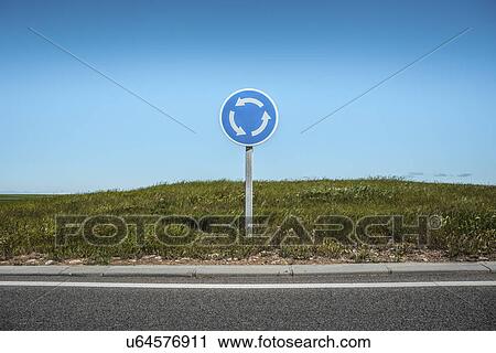 Stock Image - Roundabout sign by edge of road. Fotosearch