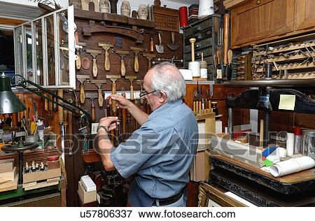 Senior man selecting tools in traditional bookbinding workshop View Large Photo Image Stock Photo - Senior man selecting tools in traditional bookbinding workshop. Fotosearch