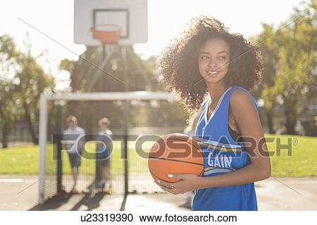 Smiling young female basketball player holding basketball View Large Photo Image Stock Image - Smiling young female basketball player holding basketball. Fotosearch