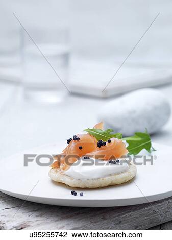 Smoked salmon and cream cheese blinis on wafer biscuit with caviar and rocket leaves garnish View Large Photo Image Stock Image - Smoked salmon and cream cheese blinis on wafer biscuit with caviar and rocket leaves garnish. Fotosearch