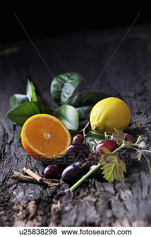 Still life of cut orange, lemon, red grapes and cinnamon sticks on bark View Large Photo Image Stock Photo - Still life of cut orange, lemon, red grapes and cinnamon sticks on bark. Fotosearch