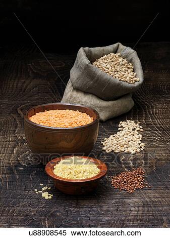 Stock Photography - Still life with bowls of red lentils and grains with sack of seeds. Fotosearch