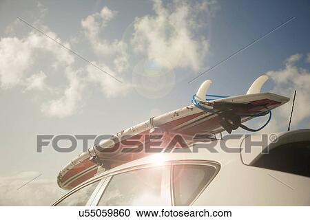 Stock Image - Surfboard on top of car. Fotosearch